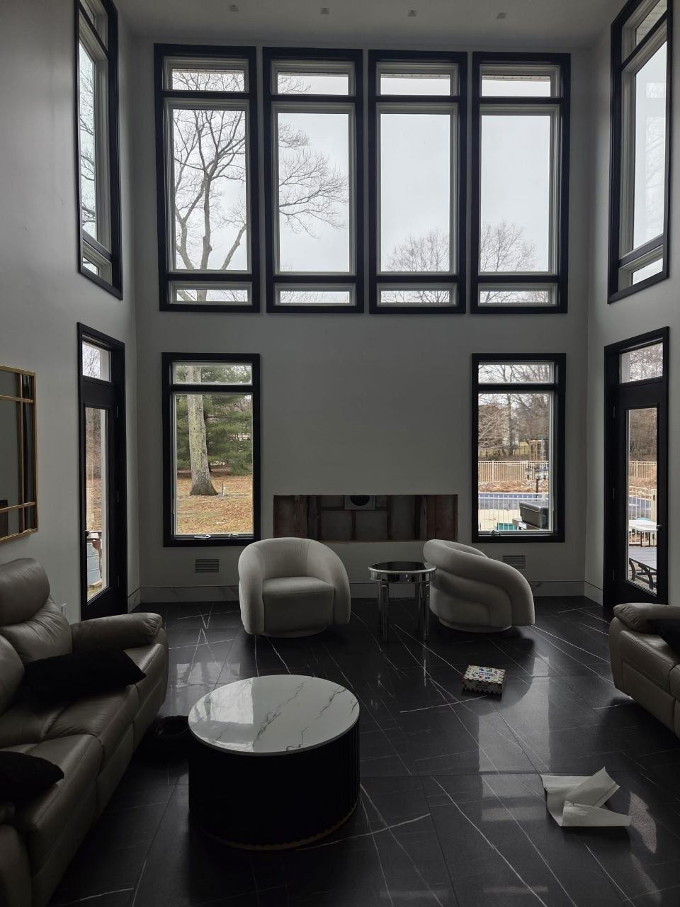 Two-story living room with a bare fireplace opening.