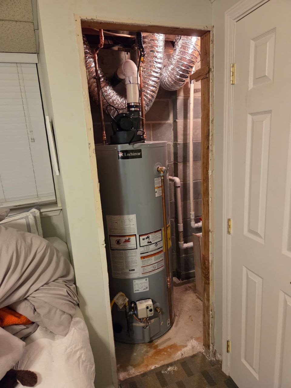 Open framed closet around a water heater with no door.