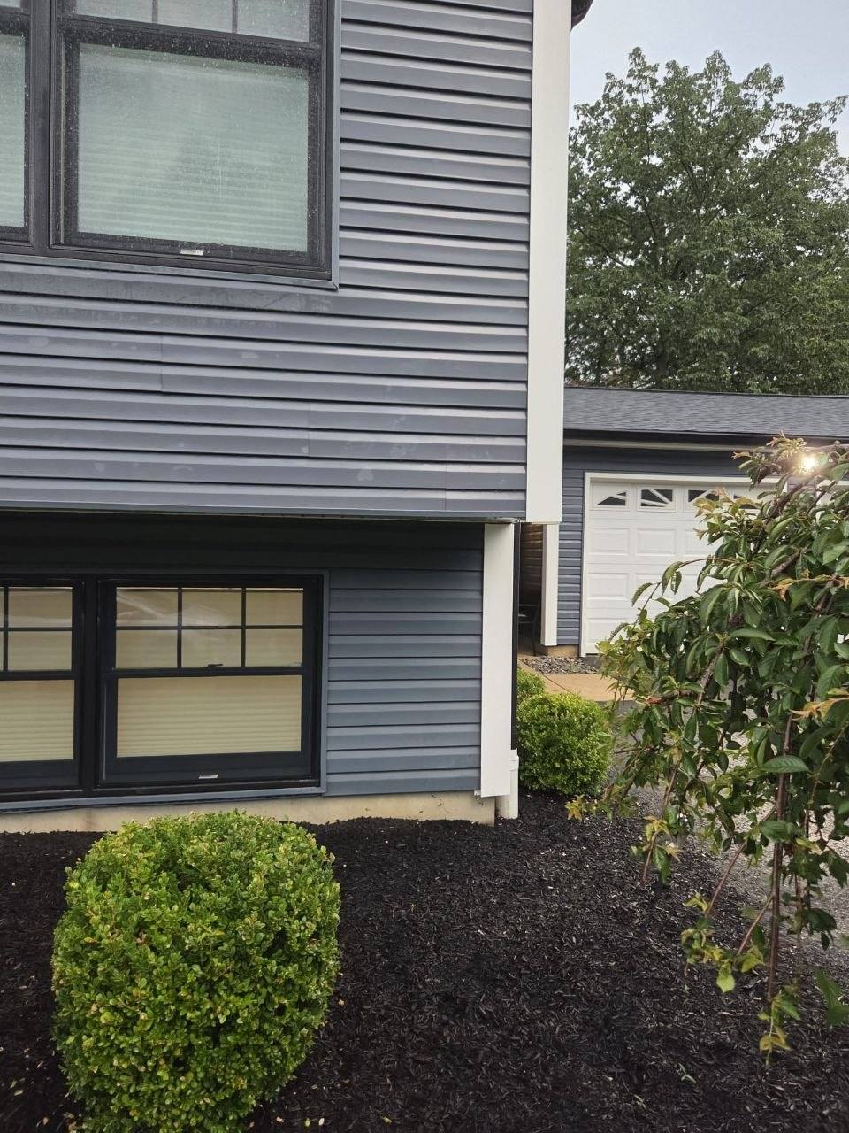 Gray siding corner with no house number.