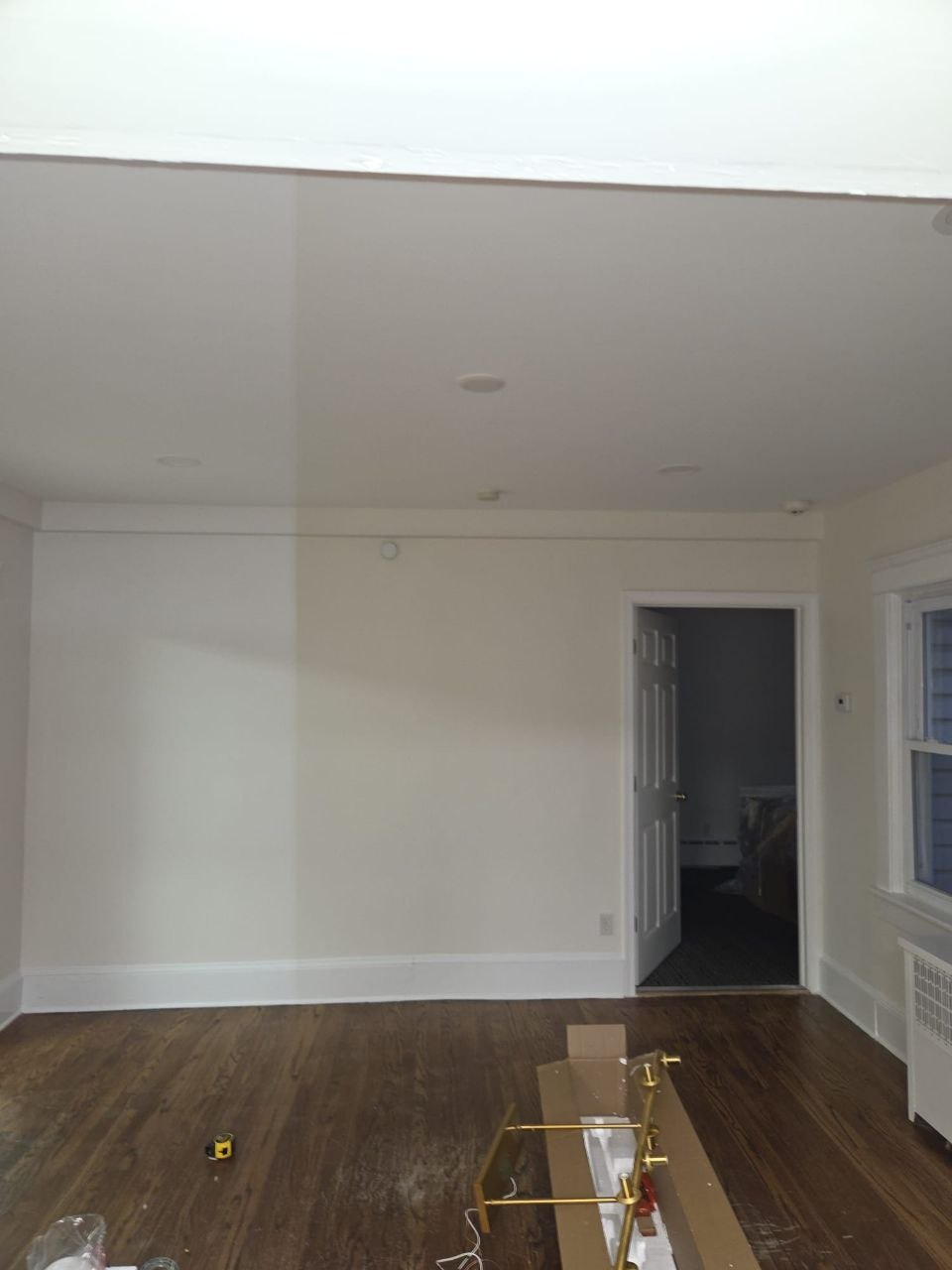 Empty living room with a stained ceiling before new lighting.
