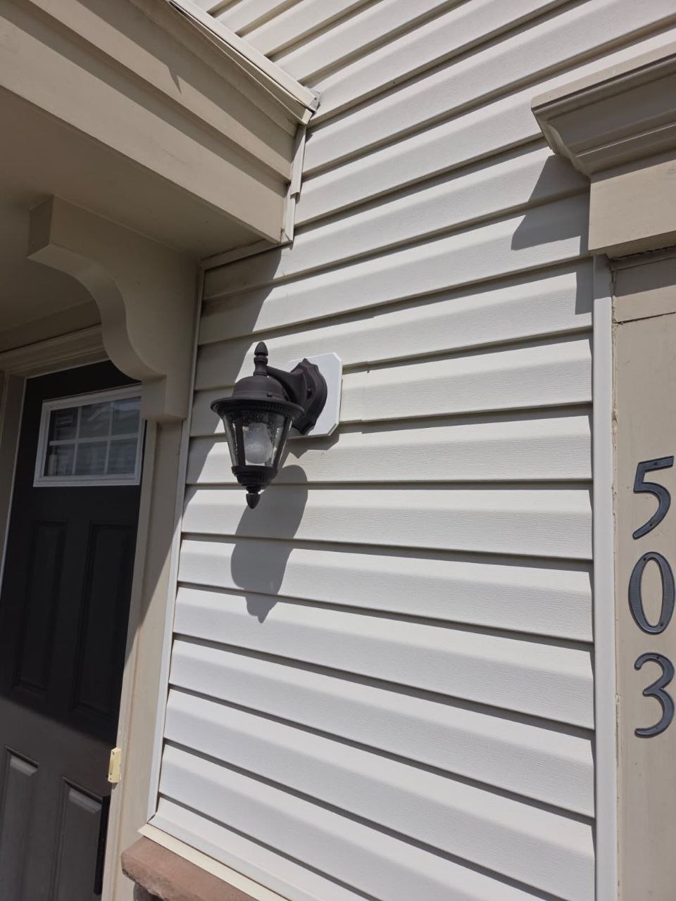 Finished lantern mount beside the front door and house number.