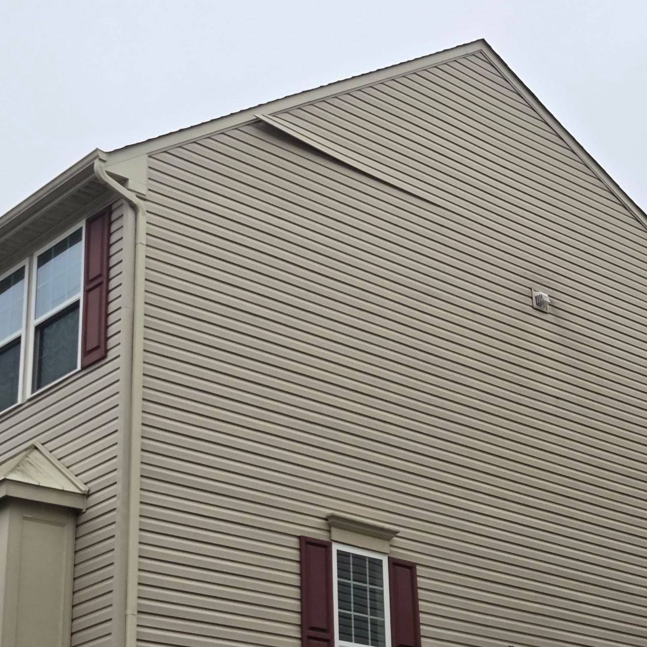 Vinyl siding on a gable pulled loose from the house.