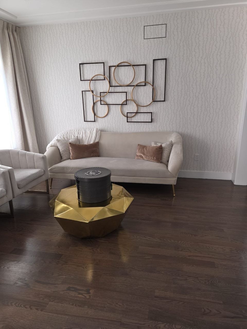 Same wall with metal circle and rectangle art hung in a grid.